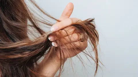 Mujer con las puntas del cabello dañadas Mujer con las puntas del cabello dañadas