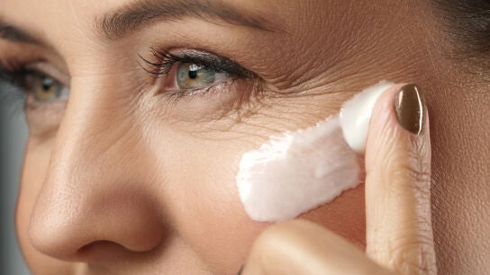 Mujer aplic&aacute;ndose crema en la cara