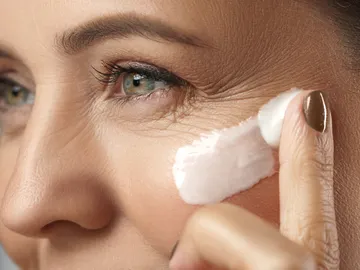 Mujer aplicándose crema en la cara Mujer aplicándose crema en la cara