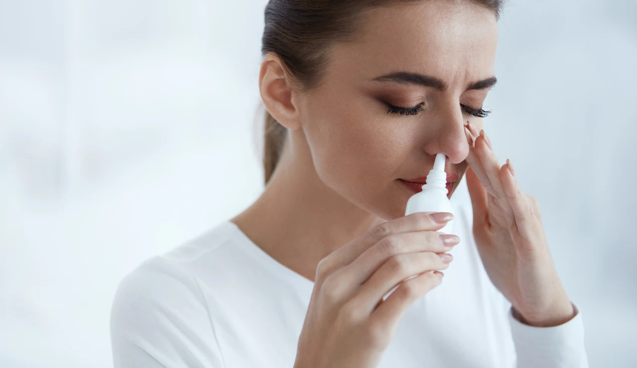 Una mujer usando un espray nasal descongestivo