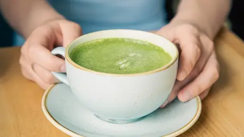 Mujer sujetando una taza de té matcha Mujer sujetando una taza de té matcha