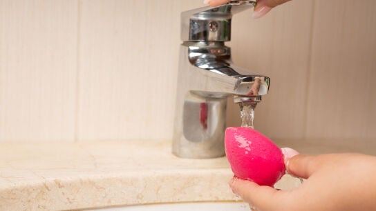 Mujer lavando una esponja de maquillaje