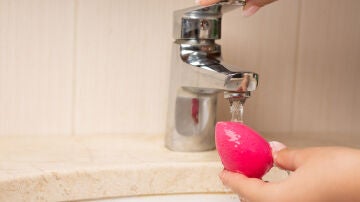 Mujer lavando una esponja de maquillaje 