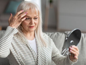Mujer contemplando sus signos de envejecimiento