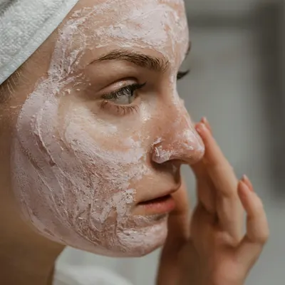 Mujer aplicándose una mascarilla en la cara