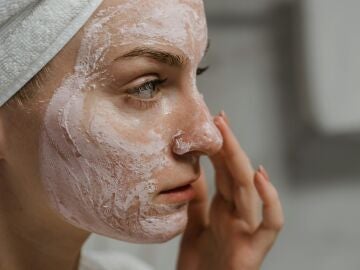 Mujer aplicándose una mascarilla en la cara