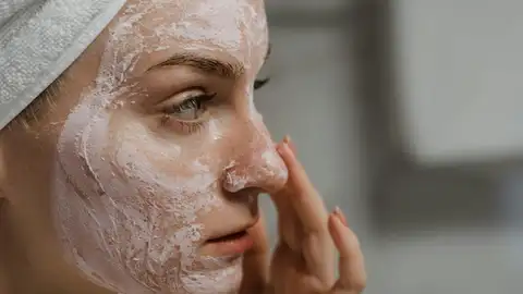 Mujer aplicándose una mascarilla en la cara Mujer aplicándose una mascarilla en la cara