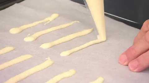 Cubre 2 bandejas de horno con papel de horno y extiende unas tiras Cubre 2 bandejas de horno con papel de horno y extiende unas tiras