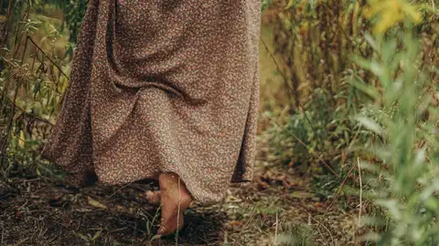 Una mujer caminando descalza en el bosque. Una mujer caminando descalza en el bosque.