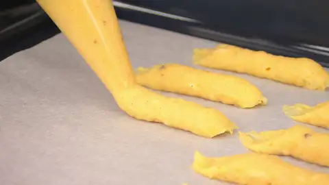 Corta la punta de la manga pastelera y forma unos bastones Corta la punta de la manga pastelera y forma unos bastones