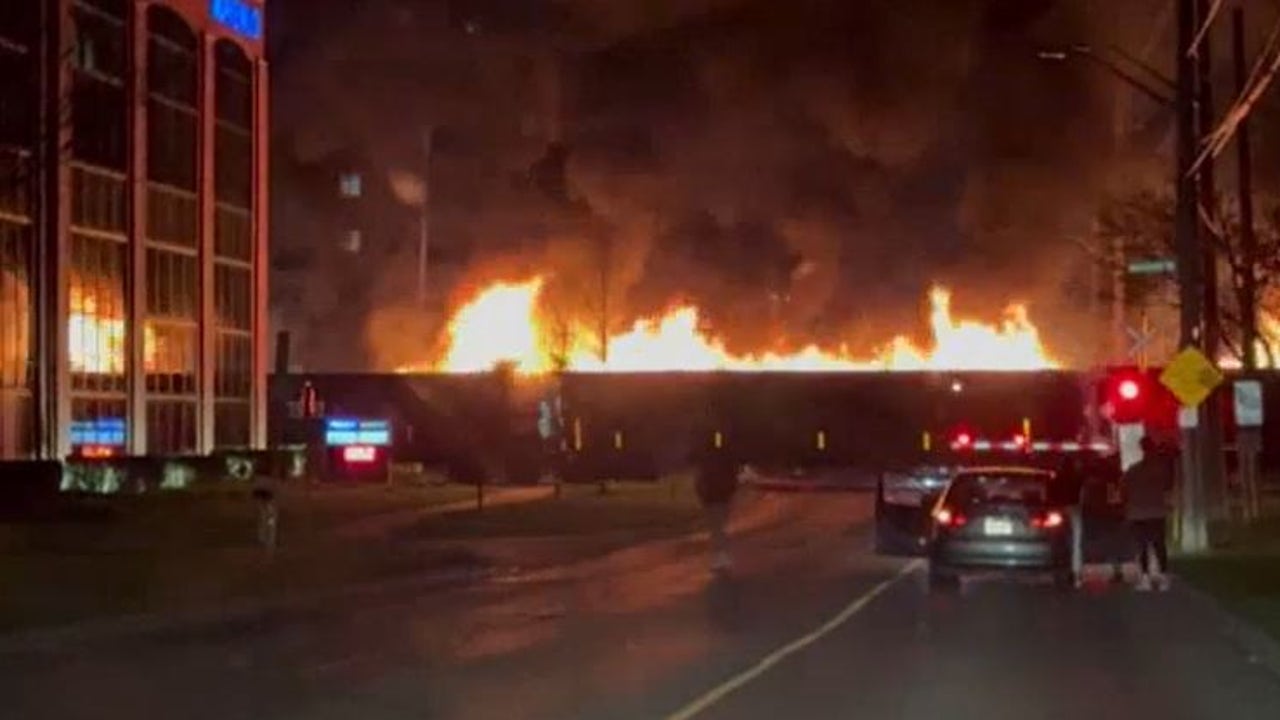 A completely burned train passes through the center of a Canadian city
