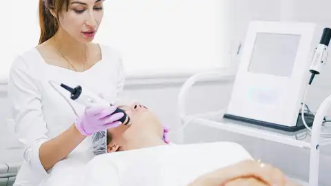 Una mujer se realiza un tratamiento en la piel del rostro Una mujer se realiza un tratamiento en la piel del rostro