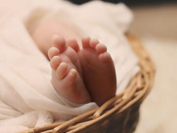 Pies de un bebé en una canastilla de mimbre