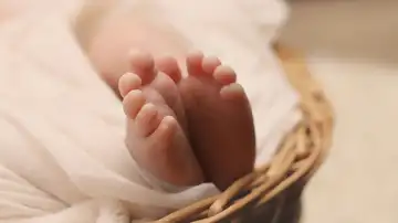 Pies de un bebé en una canastilla de mimbre