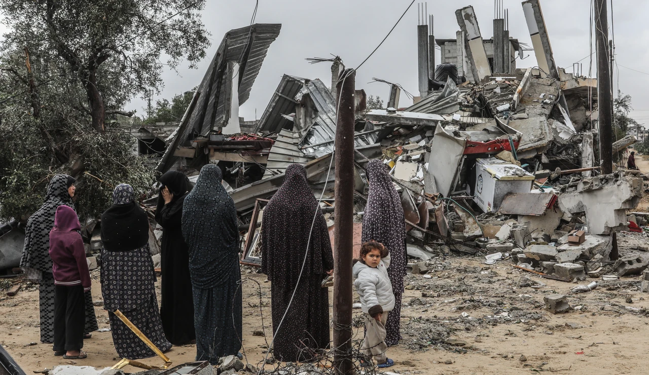 Palestinos viendo los restos de una vivienda en Rafah
