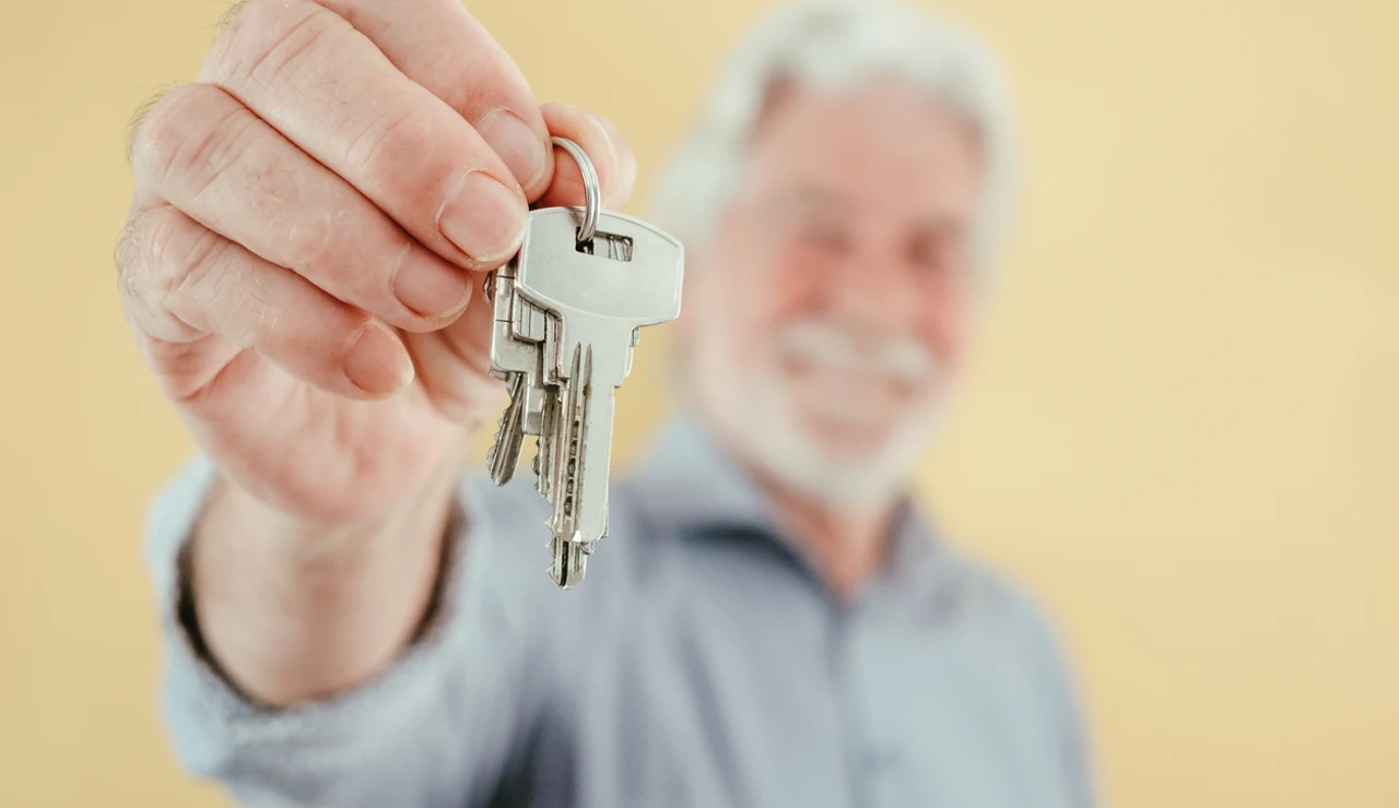 Persona mayor entrega las llaves de su casa