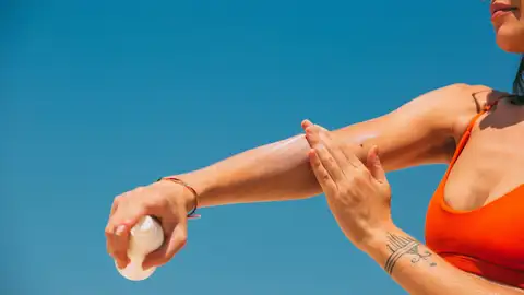 Mujer aplicándose crema solar Mujer aplicándose crema solar