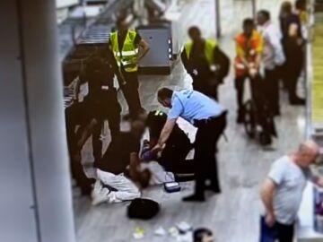 Agentes de la Guardia Civil atiende a un pasajero en el Aeropuerto de El Prat (Barcelona)