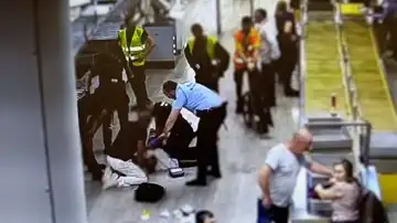 Agentes de la Guardia Civil atiende a un pasajero en el Aeropuerto de El Prat (Barcelona)