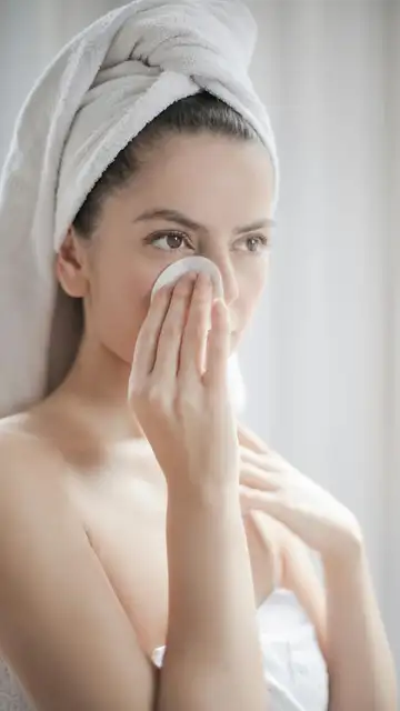 Mujer limpiándose la cara con un algodón Mujer limpiándose la cara con un algodón
