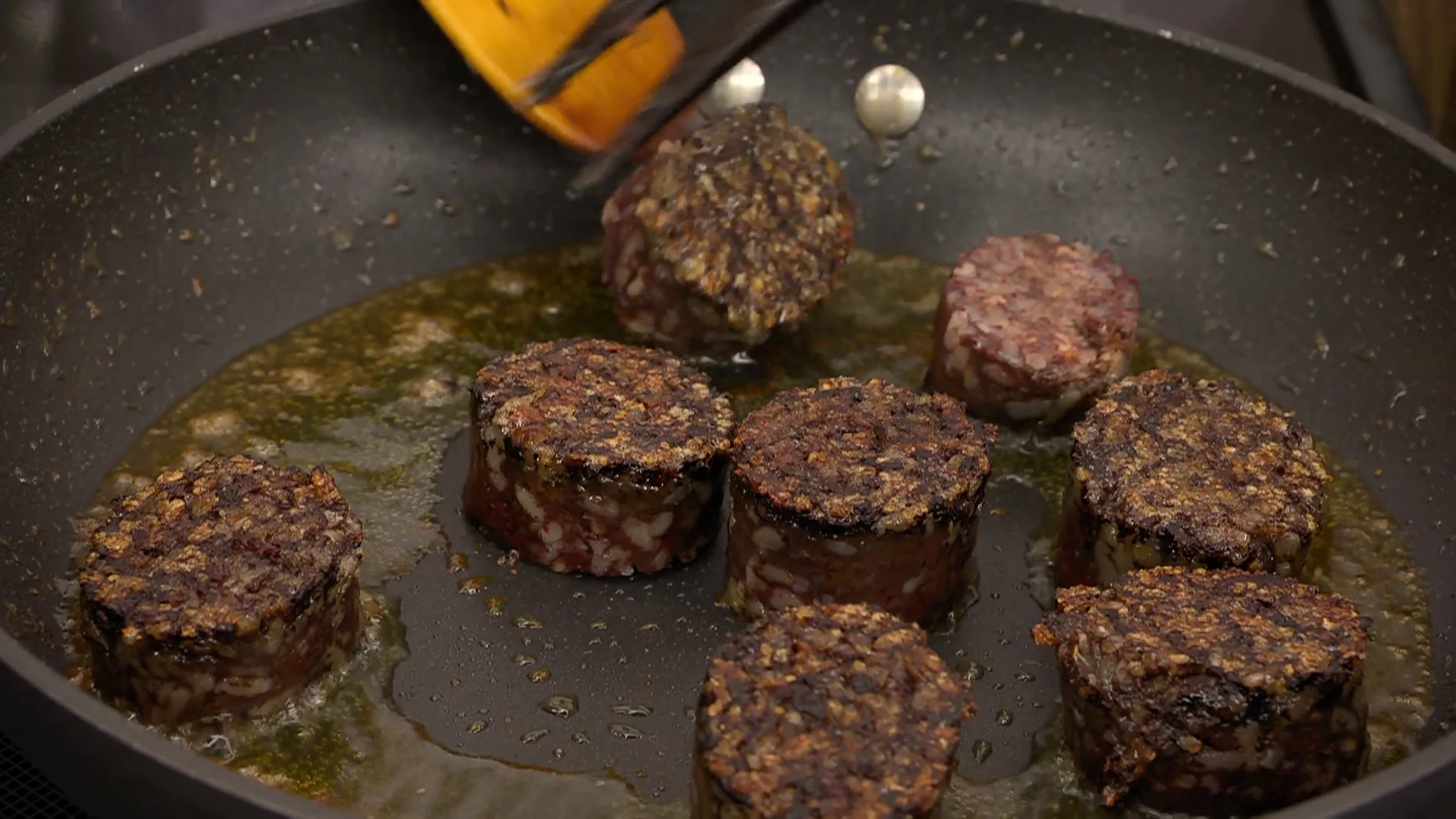 Retira la piel de la morcilla, córtala en 8 trozos, agrégala a la sartén y dórala por los 2 lados Retira la piel de la morcilla, córtala en 8 trozos, agrégala a la sartén y dórala por los 2 lados