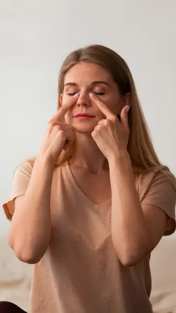 Mujer masajeándose la parte inferior del párpado Mujer masajeándose la parte inferior del párpado