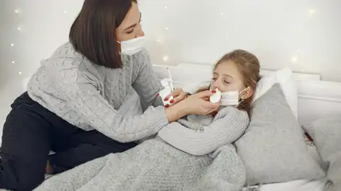 Una madre cuida a su hija enferma Una madre cuida a su hija enferma