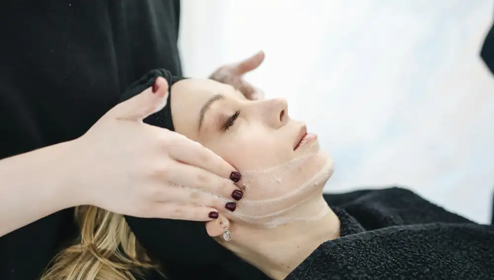 Mujer aplicándose un tratamiento de cosmética