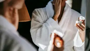 Mujer aplicándose una crema cosmética