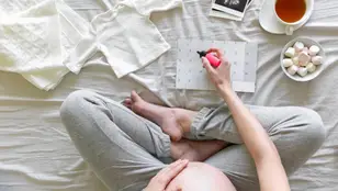 Una mujer embarazada con un calendario