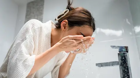 Mujer lavándose la cara Mujer lavándose la cara