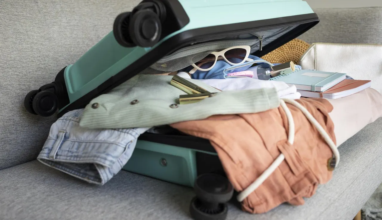 Imagen de archivo de una maleta llena de equipaje.