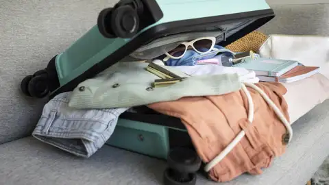 Imagen de archivo de una maleta llena de equipaje. Imagen de archivo de una maleta llena de equipaje.