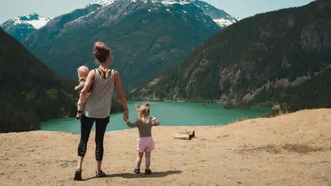 Una madre en la montaña de excursión con sus hijos Una madre en la montaña de excursión con sus hijos