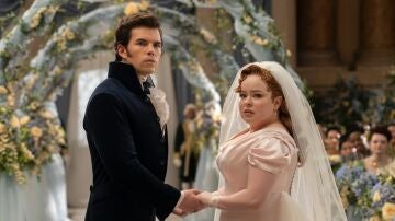 Luke Newton como Colin Bridgerton y Nicola Coughlan como Penelope Featherington en la boda de sus personajes