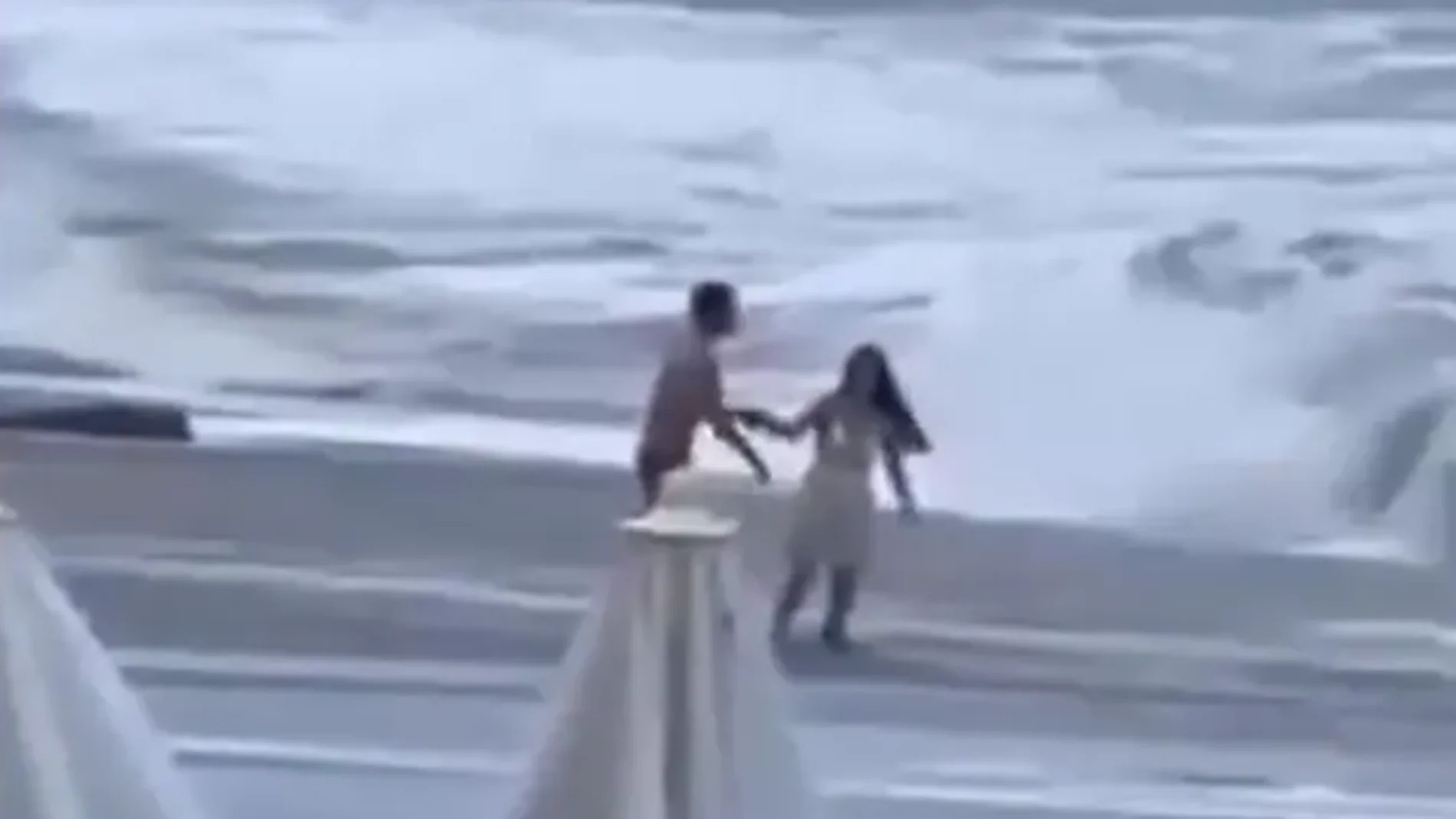 La pareja jugando entre las olas La pareja jugando entre las olas