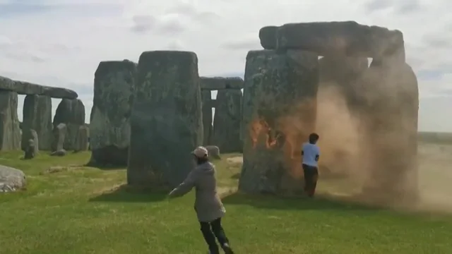 Dos ecologistas son roc&iacute;an con pintura naranja al monumento megal&iacute;tico Stonehenge