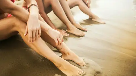 Un grupo de chicas y mujeres en la arena de la playa cerca del mar Un grupo de chicas y mujeres en la arena de la playa cerca del mar