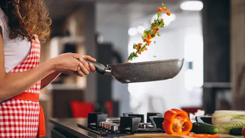 Mujer cocinando verduras Mujer cocinando verduras