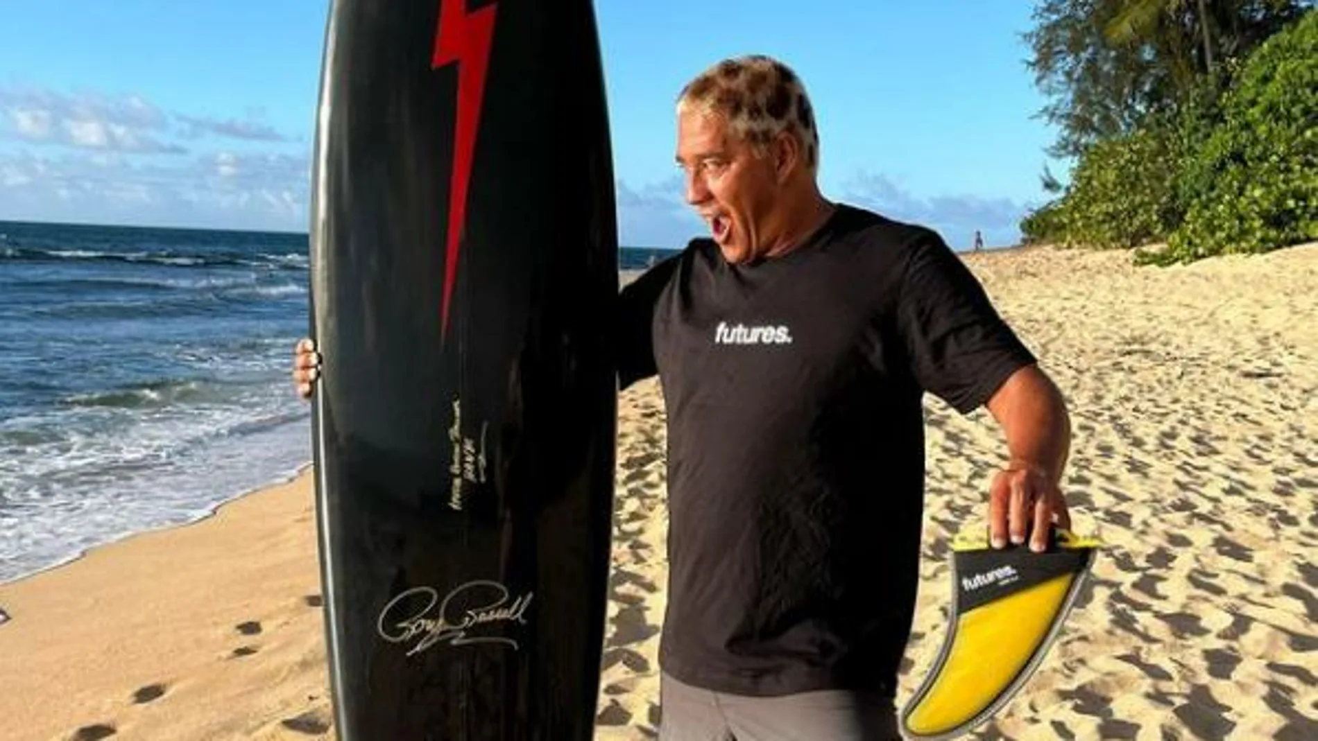 Tamayo Perry en una imagen posando con su tabla de surf