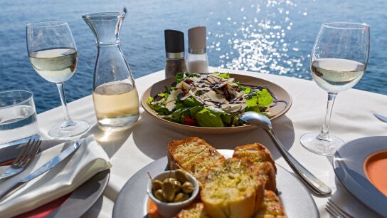 Una ensalada y un aperitivo t&iacute;pico de la dieta mediterr&aacute;nea, frente al mar
