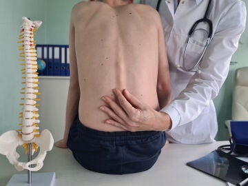 Médico examinando la columna vertebral