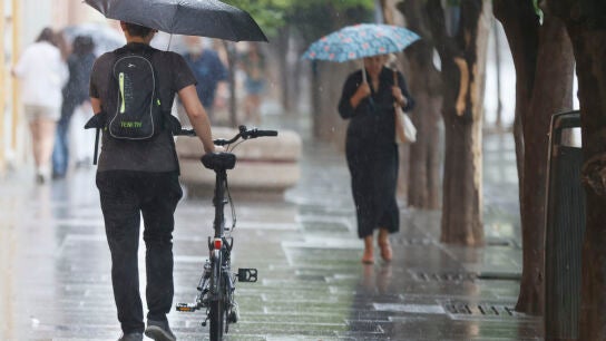 Imagen de personas con paraguas por la lluvia