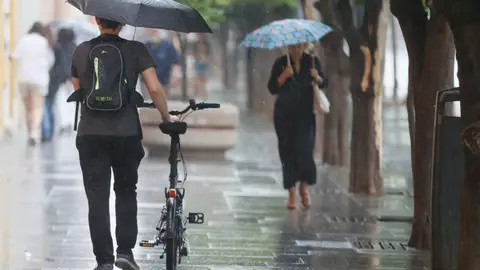 Imagen de personas con paraguas por la lluvia Imagen de personas con paraguas por la lluvia