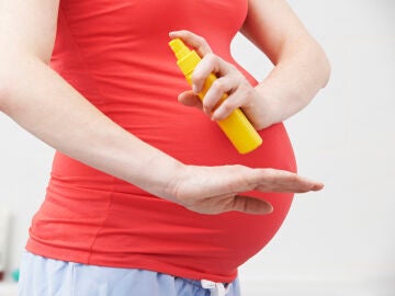 Una embarazada usando un producto antimosquitos