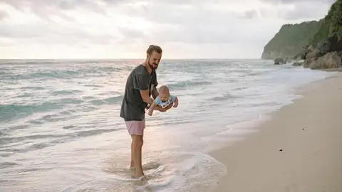 Un padre con su hijo pequeño en la playa Un padre con su hijo pequeño en la playa