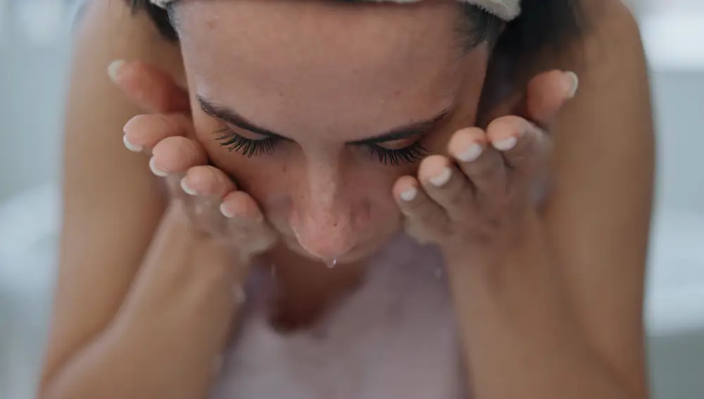 Mujer lavándose la cara Mujer lavándose la cara