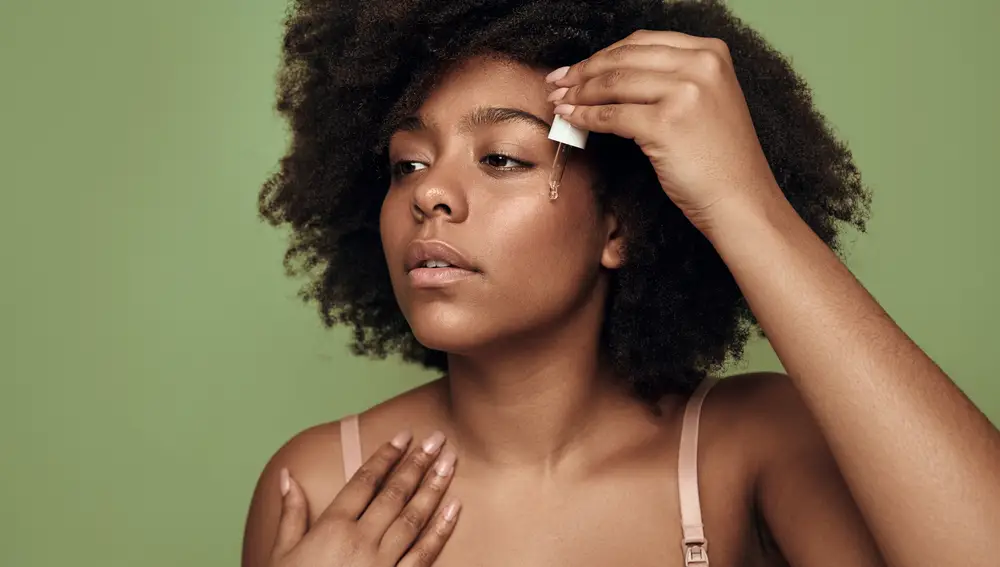 Mujer echándose sérum Mujer echándose sérum