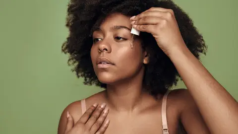 Mujer echándose sérum Mujer echándose sérum