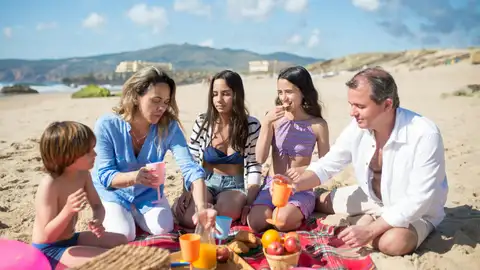 Una familia disfruta de un pícnic en la playa Una familia disfruta de un pícnic en la playa